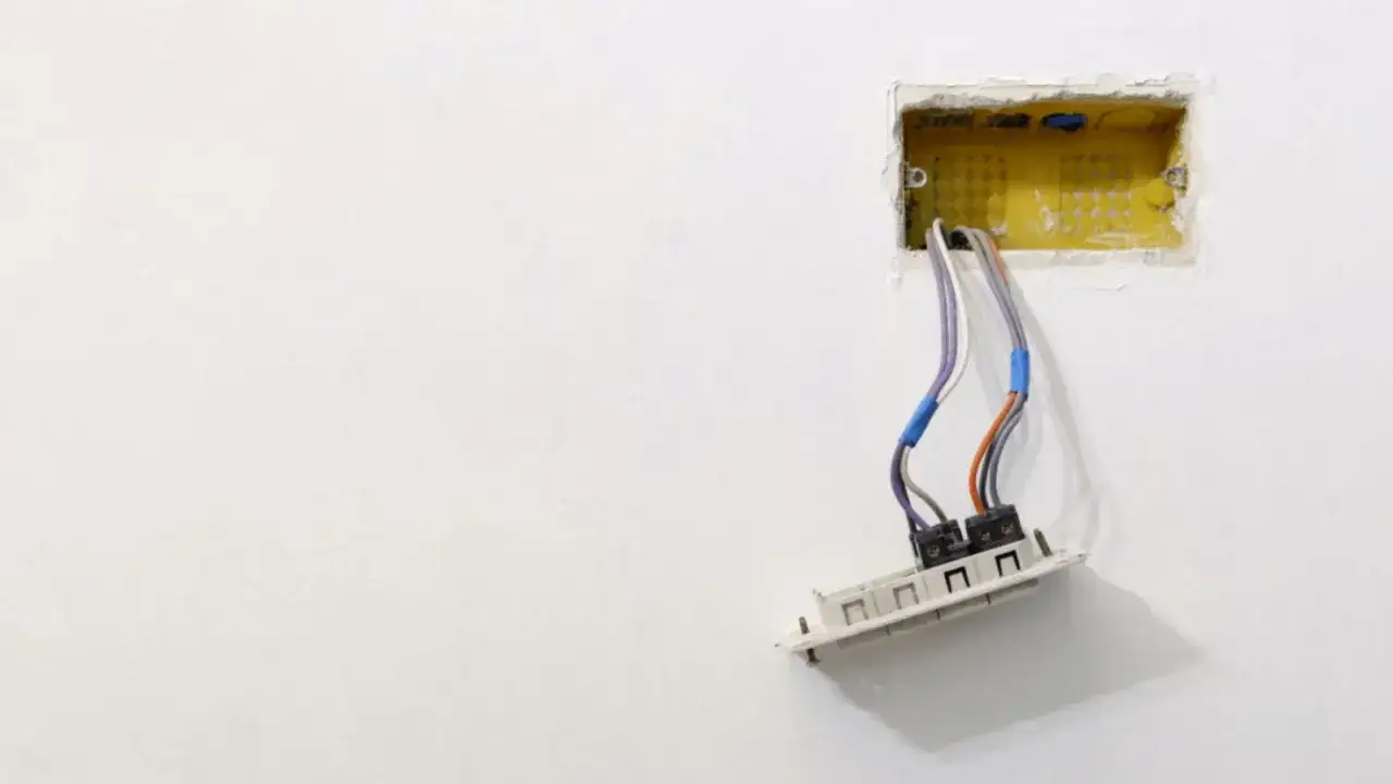 Wystające puszki elektryczne z luźnymi przewodami, gotowe do podłączenia.