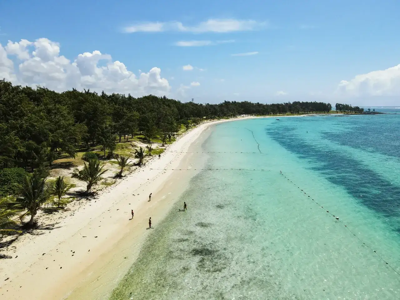 Piękna plaża na Mauritiusie w listopadzie. Słoneczna pogoda, turkusowa woda i zielone palmy. Idealne warunki do wypoczynku.