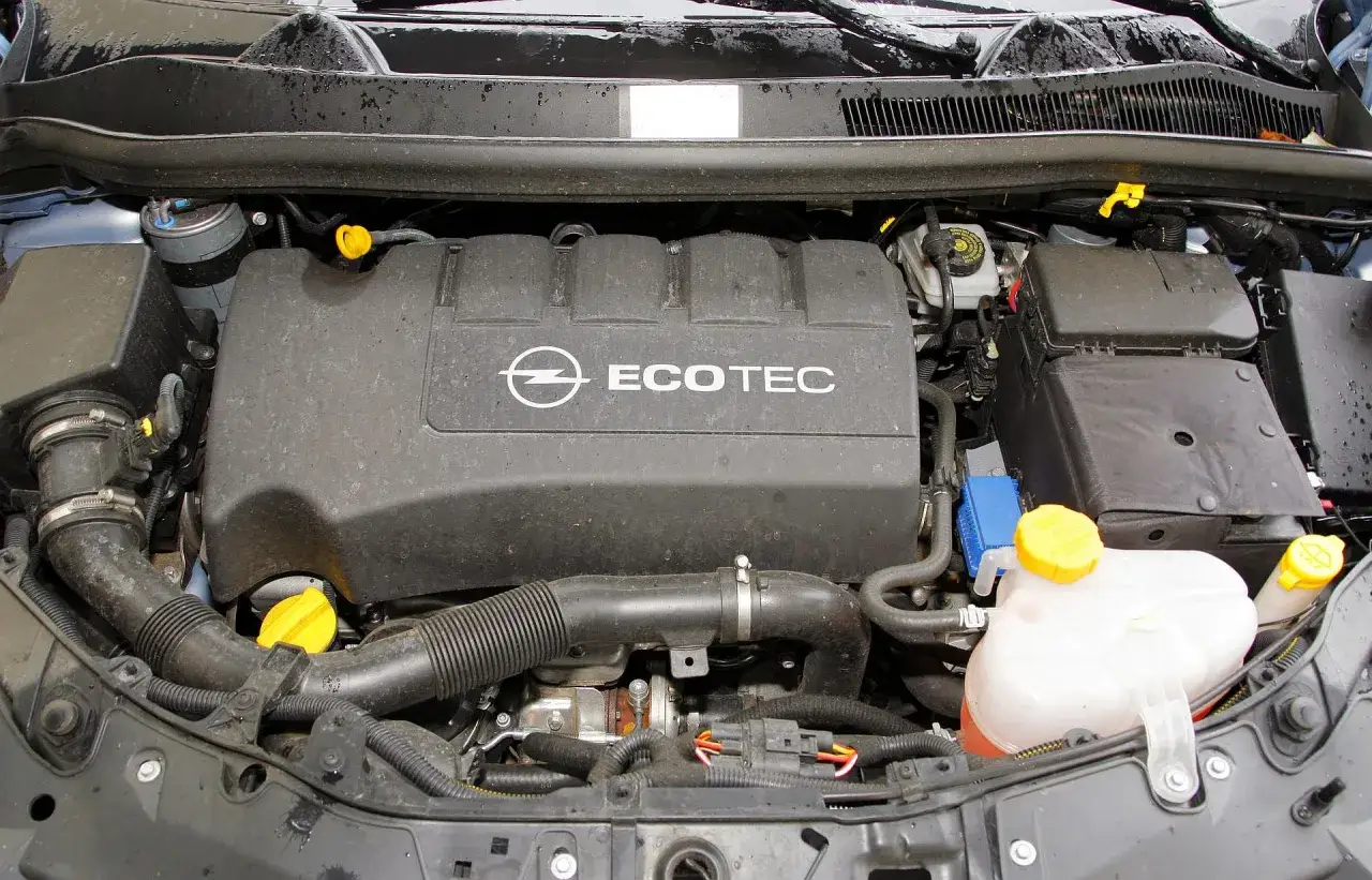 Silnik Ecotec w oplu Corsa D. Widoczny zbiornik płynu chłodniczego i elementy układu dolotowego.