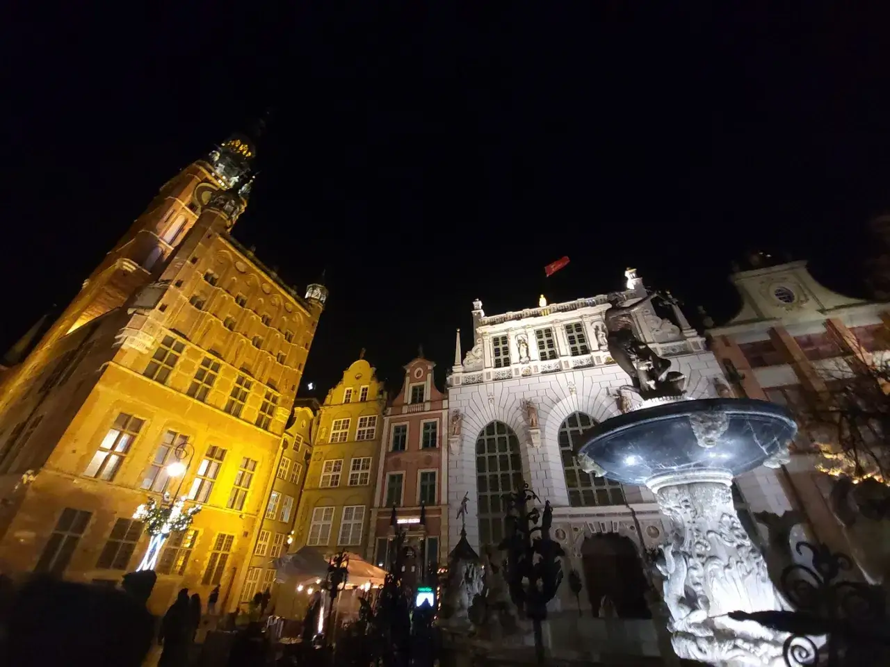 Nocny spacer po Gdańsku Stare Miasto. Fontanna Neptuna i zabytkowe kamienice w blasku iluminacji.