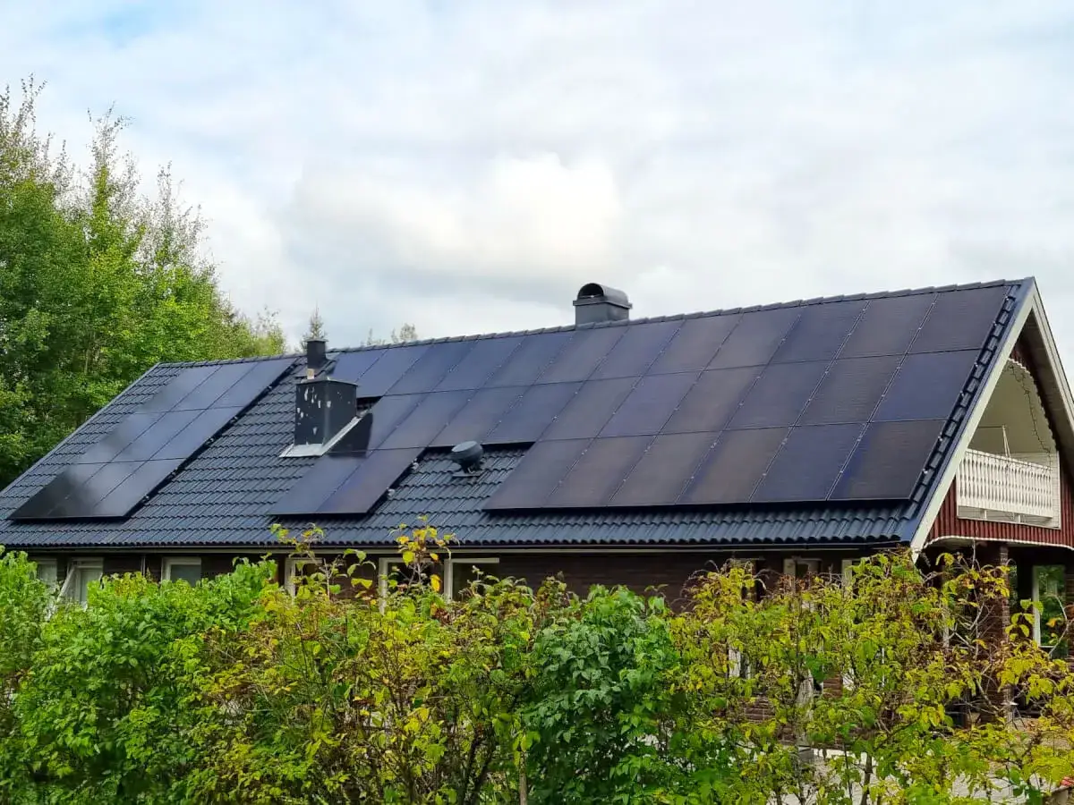 Ett hus i Sverige med ett stort antal solpaneler, inklusive en solpanel 450w, installerade p&aring; taket.