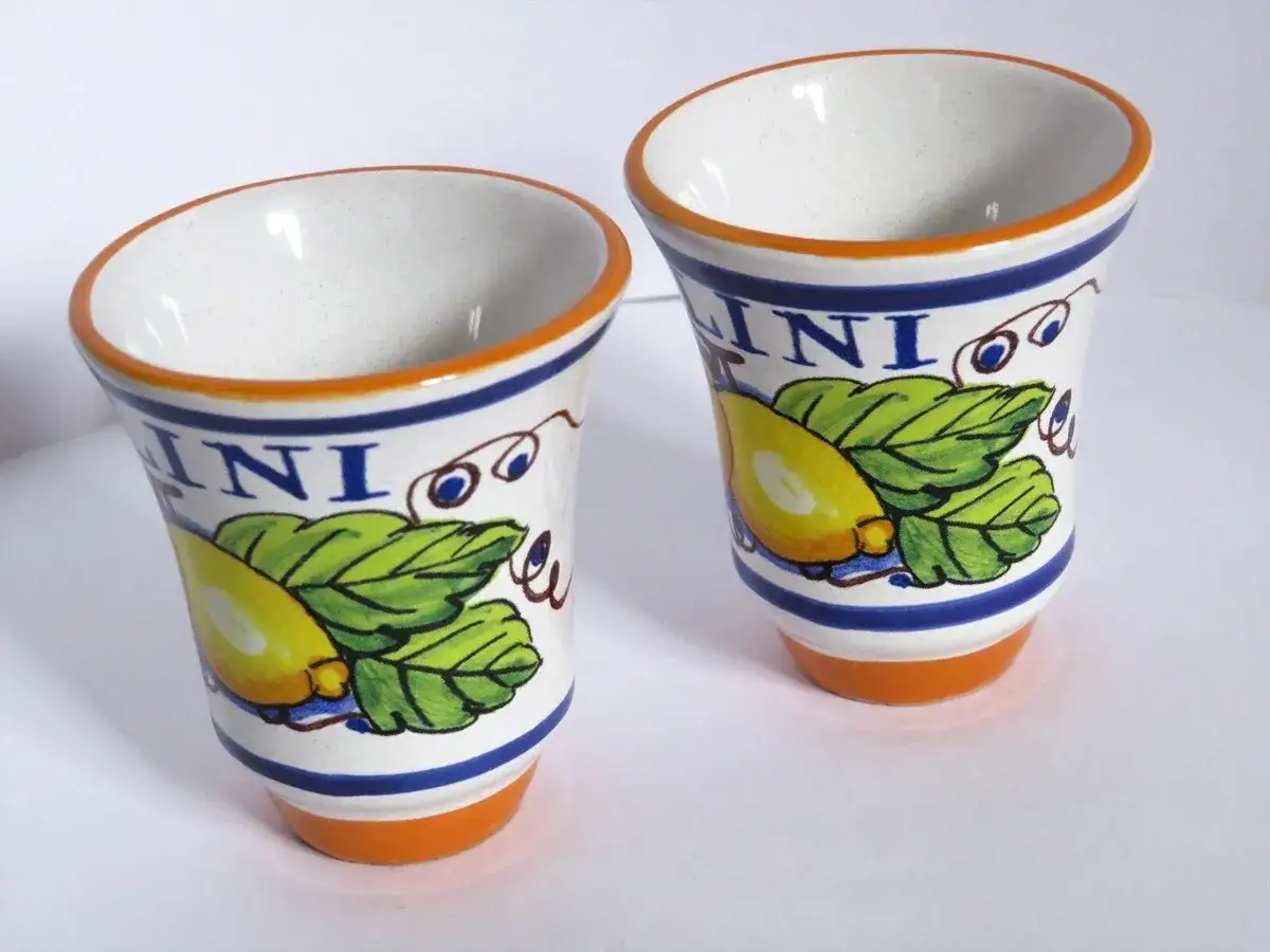 Dwa ceramiczne kieliszki z motywem cytryn i liści, idealne do serwowania limoncello. Jak pić? Schłodzone, małymi łykami!