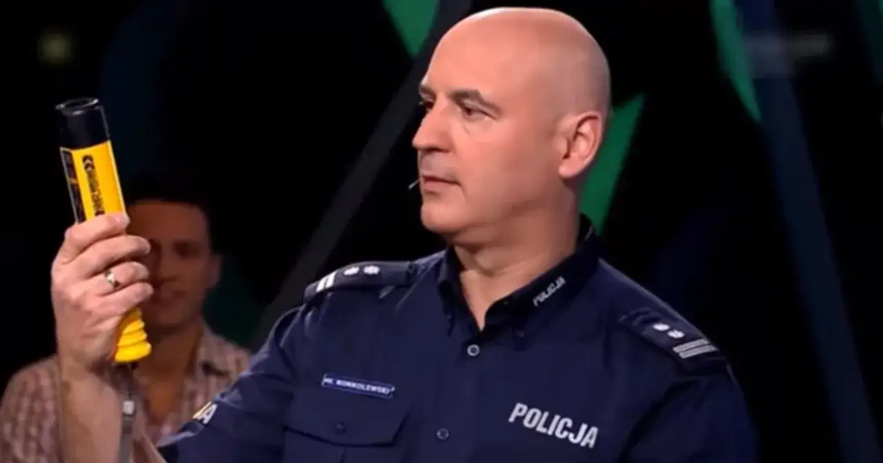 Policjant pokazuje alkomat, ostrzegając przed jazdą pod wpływem alkoholu.