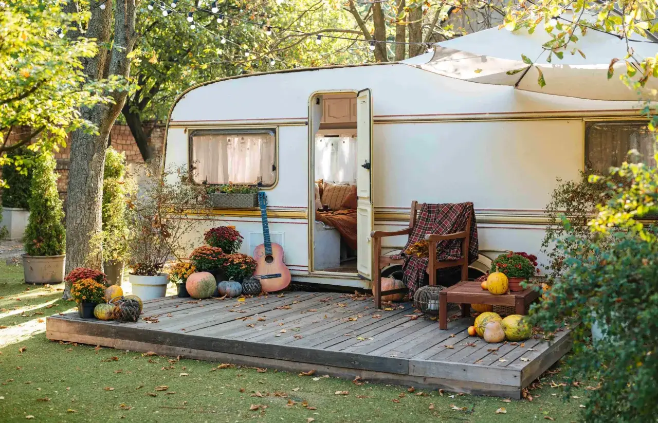 Caravane d&eacute;cor&eacute;e pour l'automne, avec guirlandes lumineuses. Id&eacute;al pour une liste des camping ouvert toute l'ann&eacute;e.