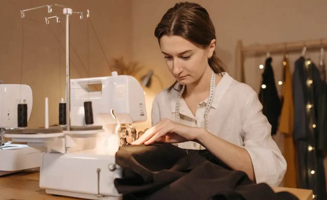 Une couturière utilise une surjeteuse pour créer un patron housse de chaise Burda.