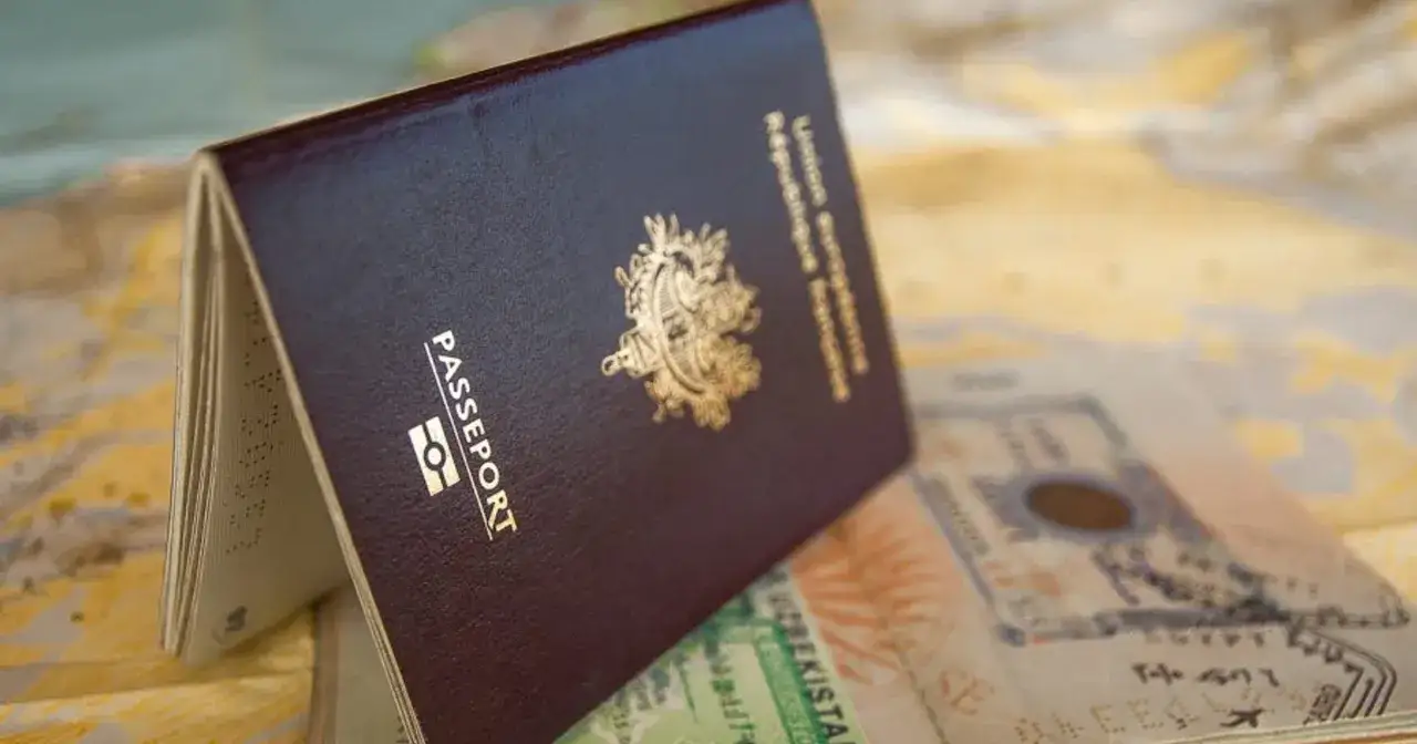 Otwarty paszport leży na mapie. Czy na Gibraltar potrzebny jest paszport? Dokument podróży z pieczątkami sugeruje planowanie wycieczki.