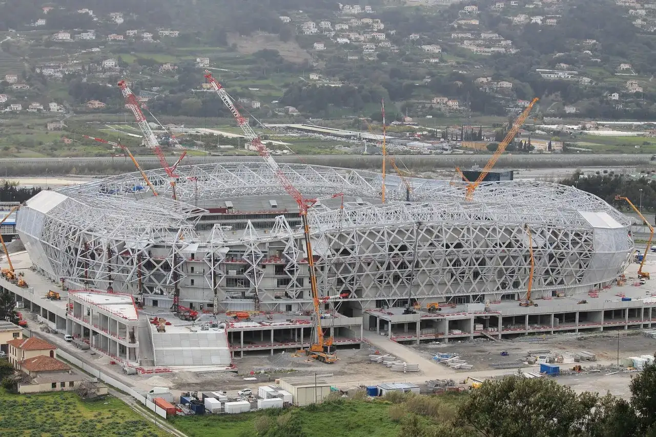 Budowa nowoczesnego stadionu w Nicei. Widać liczne dźwigi i konstrukcję obiektu.