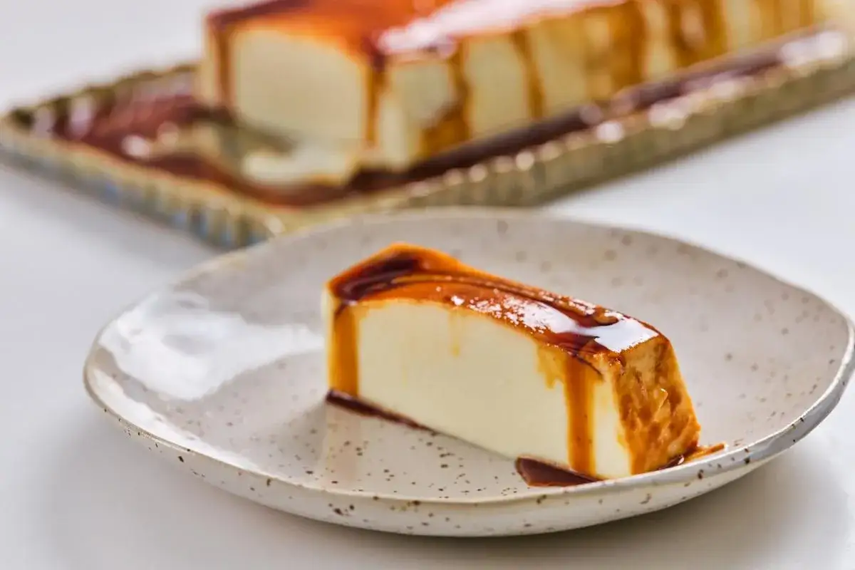 Deliciosa tarta de queso fría con caramelo líquido, servida en un plato rústico.