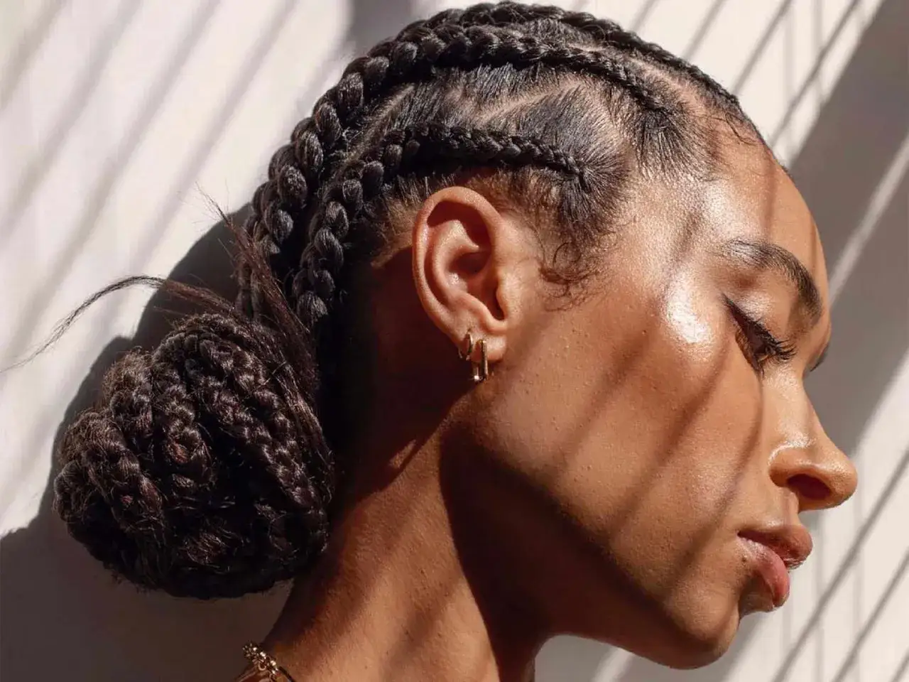 Peinados para verano: trenzas africanas recogidas en un mo&ntilde;o bajo.