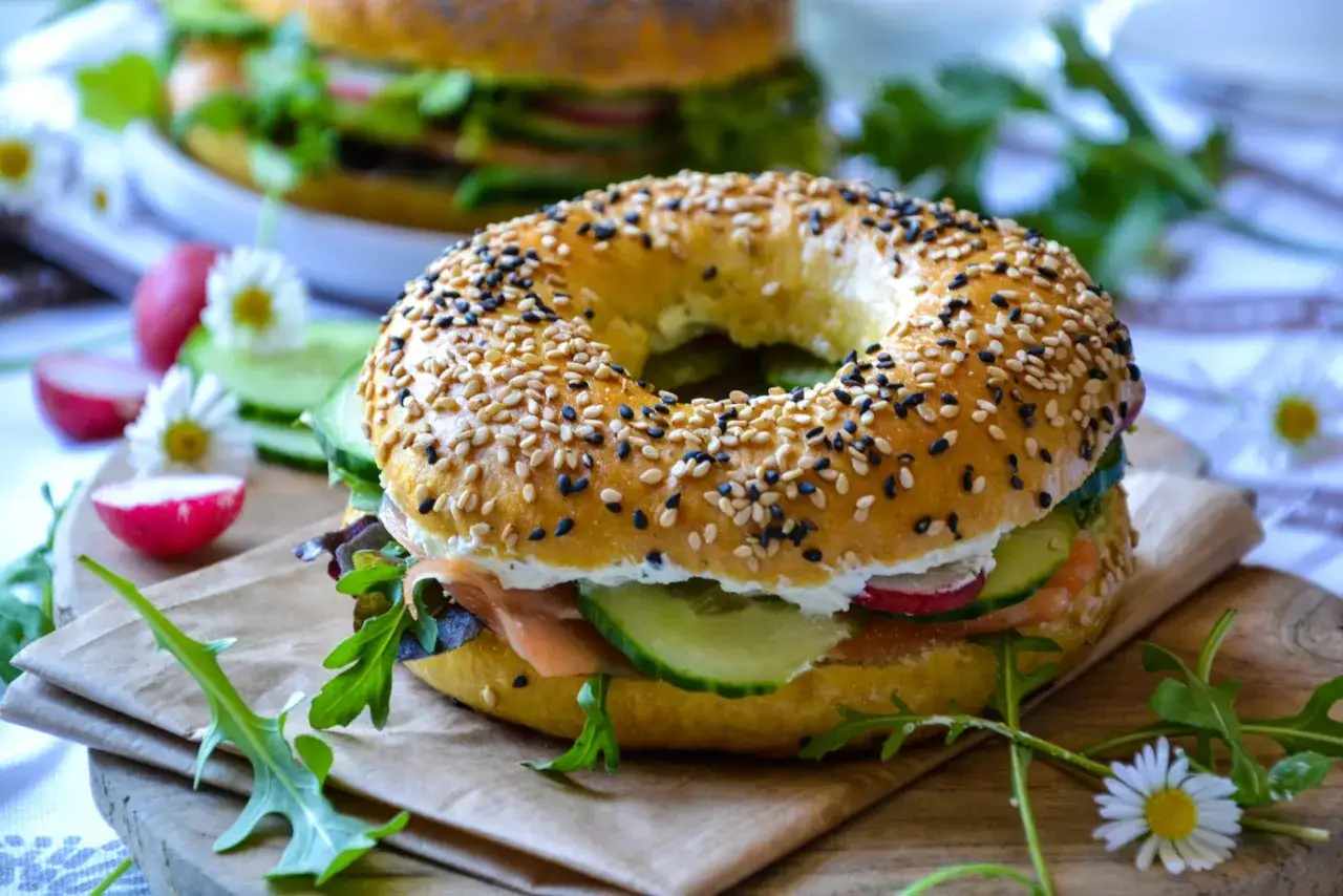 Un bagel garni de saumon fum&eacute;, concombre, radis et roquette. Un accompagnement bagel frais et color&eacute;, d&eacute;cor&eacute; de marguerites.