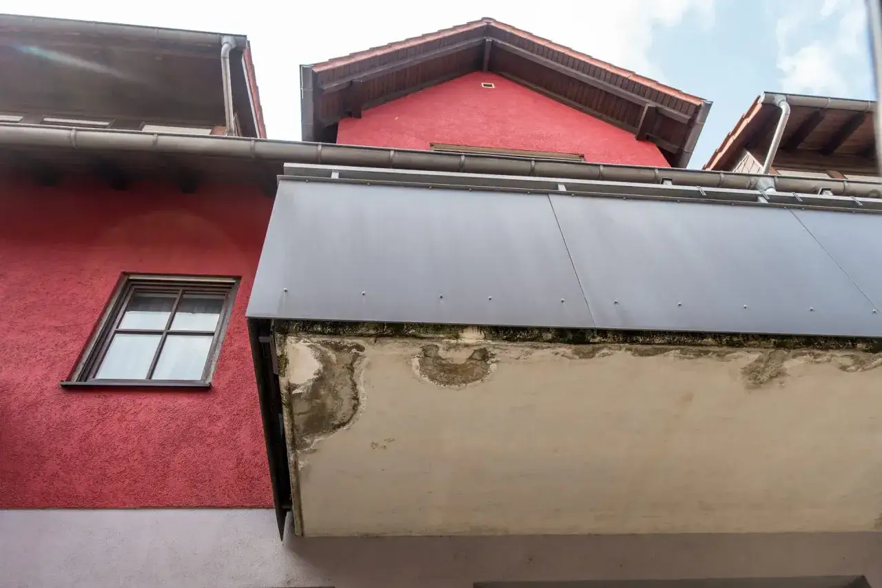 Betonplatte zeigt Wasserschäden, ein Zeichen, dass der Balkon saniert werden muss.
