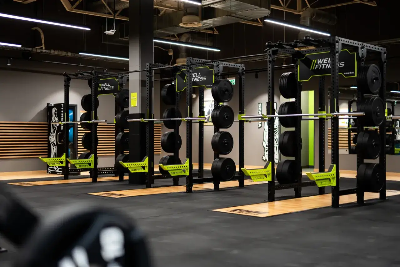 Siłownia z wolnymi ciężarami i rackami. Idealne miejsce, by sprawdzić, jaka jest karta multisport cena i zacząć trening.