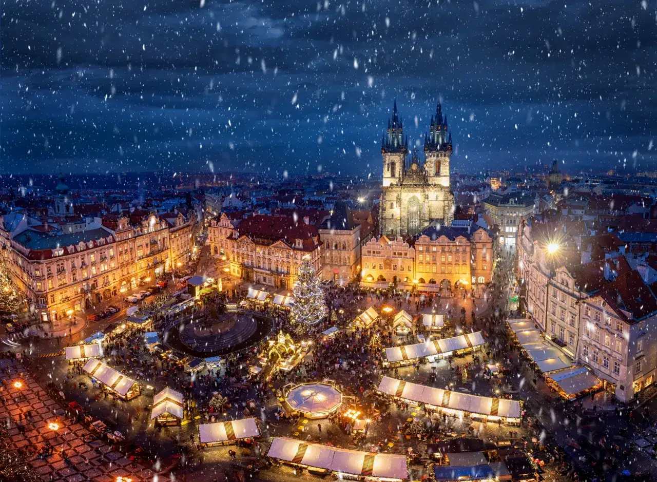 Magischer prague christmas Markt im Schnee. Der beleuchtete Weihnachtsbaum und die Stände erstrahlen im Herzen der Stadt.