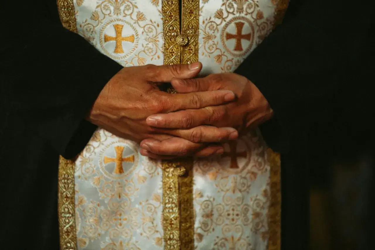 Dłonie złożone na piersi w bogato zdobionej szacie. Jak rozpoznać objawy pychy duchowej i poczucie wyższości nad innymi?