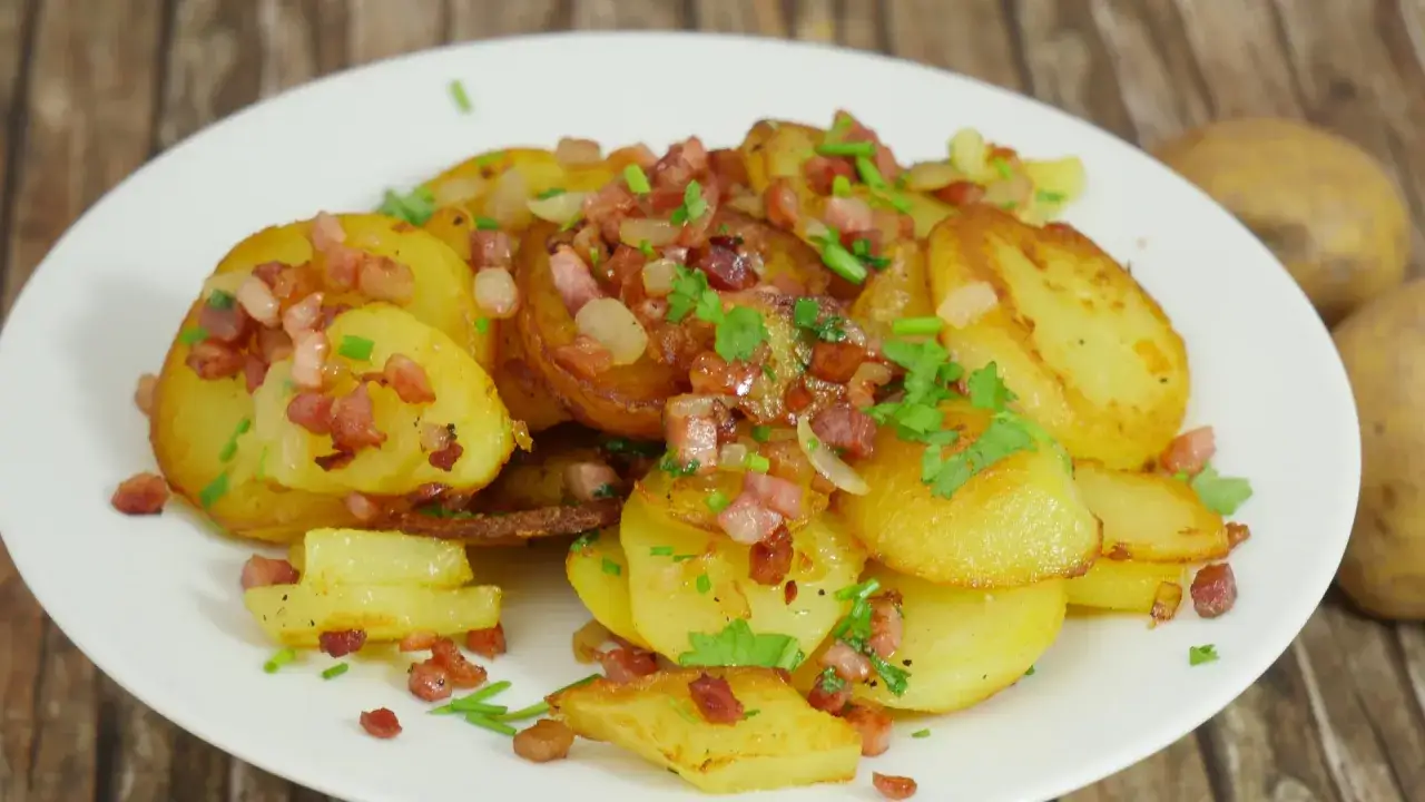 Bratkartoffeln mit Speck und Zwiebeln, garniert mit Petersilie. Ein herzhaftes Gericht, das an bremer scheerkohl erinnert.