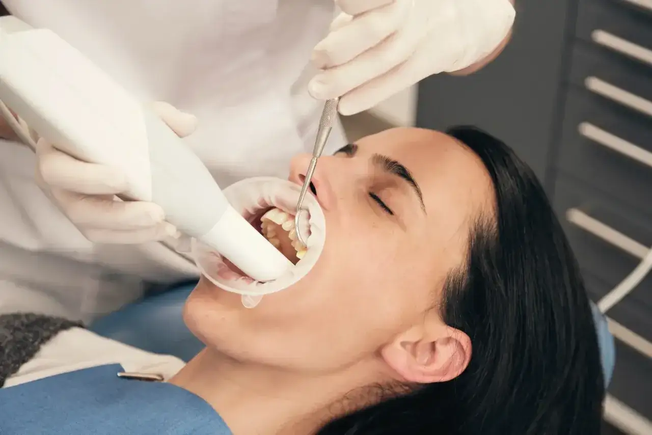 Dentysta bada zęby pacjentki. Szuka domowych sposob&oacute;w na ruszające się zęby, by pom&oacute;c jej odzyskać pewność siebie.