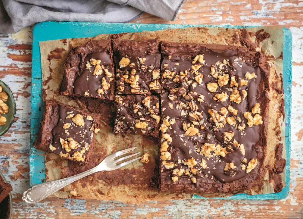 Pyszne fit brownie z fasoli bez banana, posypane orzechami włoskimi i polane czekoladą. Idealne na zdrowy deser.