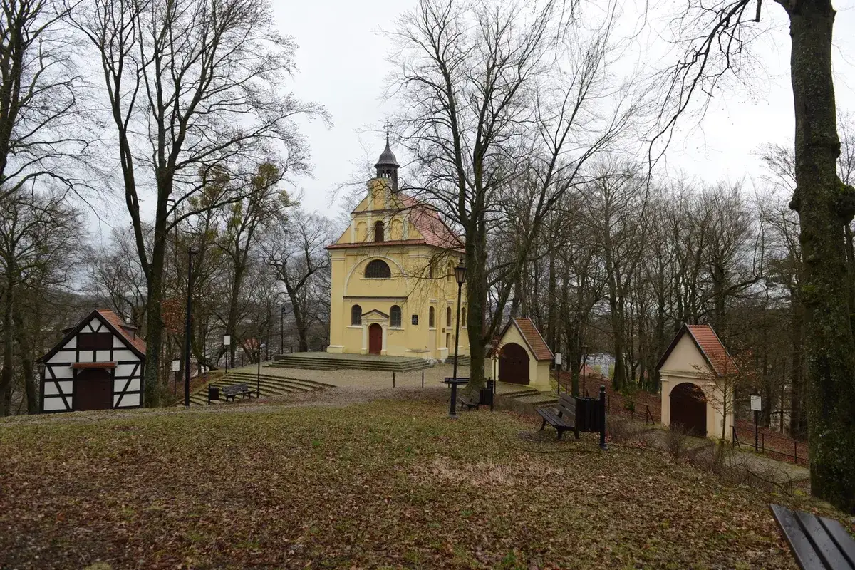 Żółta kaplica z czerwoną wieżyczką i kilkoma mniejszymi budynkami tworzy malowniczą Kalwarię Kaszubską.