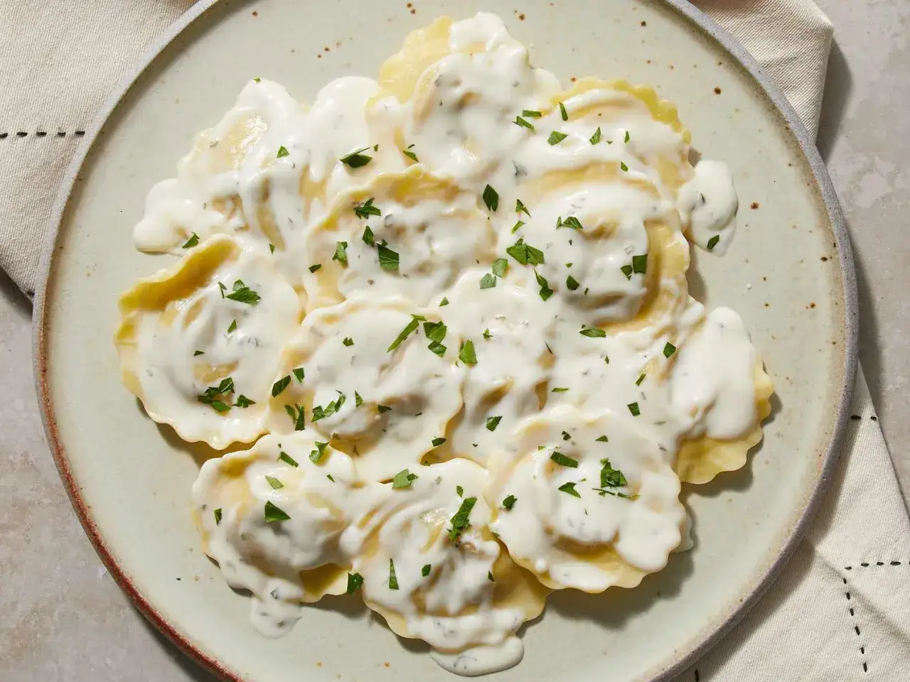 Ravioli in cremiger Sahnesauce, garniert mit Petersilie. Ein köstliches Gericht mit Sahne, das zum Genießen einlädt.