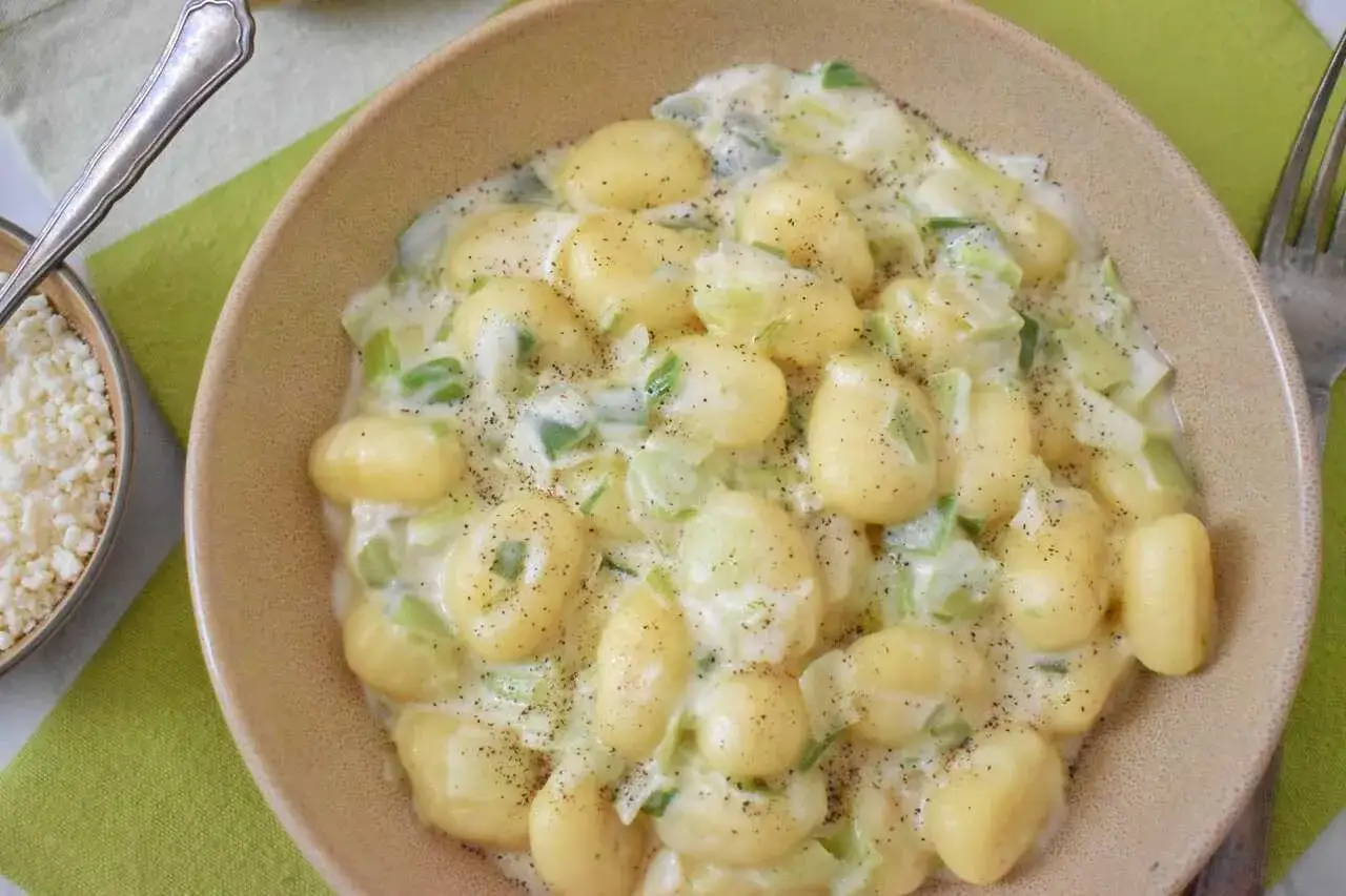 Pyszne gnocchi gorgonzola w kremowym sosie z porem, posypane świeżo mielonym pieprzem.