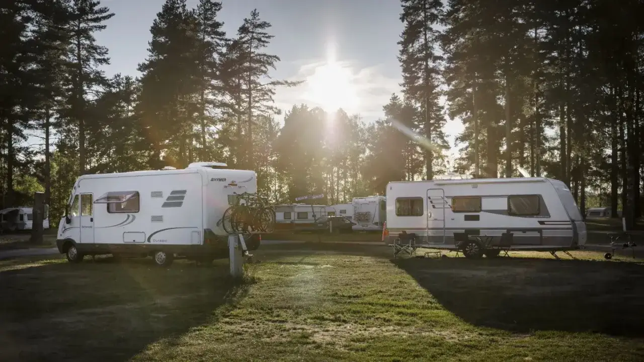 Solnedgång över husbilar och husvagnar på Mellsta Camping Borlänge.