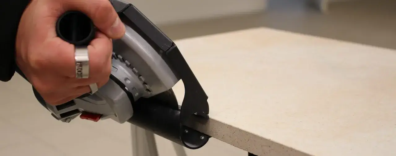 Hand mit Werkzeug beim pr&auml;zisen Fliesenschneiden.