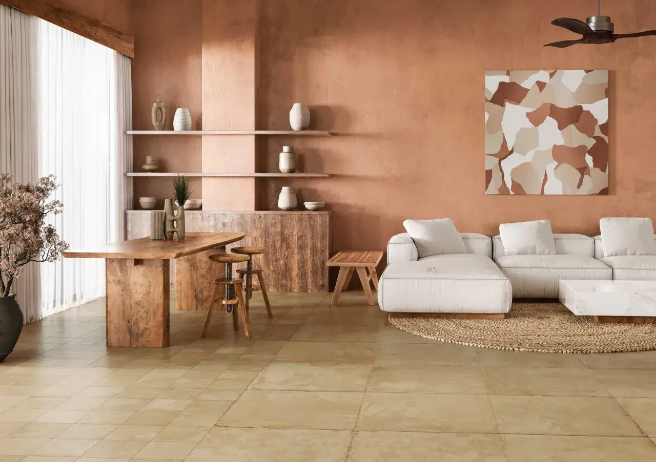 Salón con paredes terracota, muebles de madera rústica y un sofá blanco, evocando la arquitectura mediterránea.