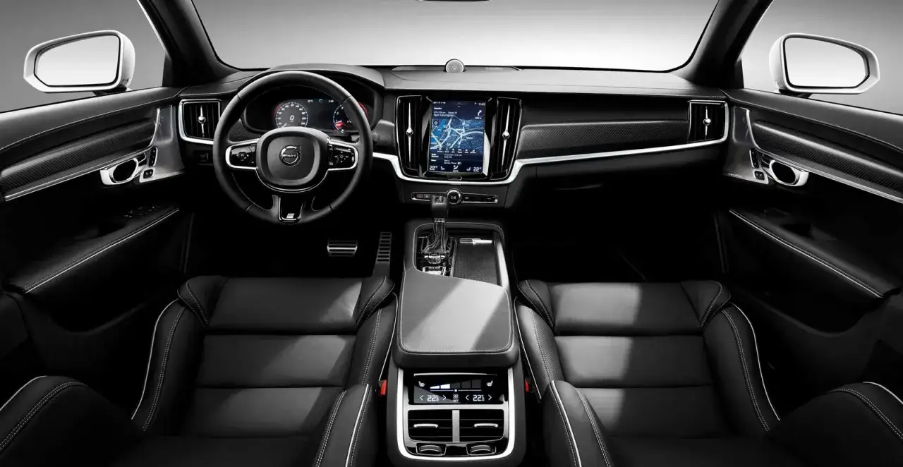Interior de un Volvo S90, con asientos de cuero negro, pantalla t&aacute;ctil central y volante. Las opiniones sobre el Volvo S90 destacan su confort y dise&ntilde;o.