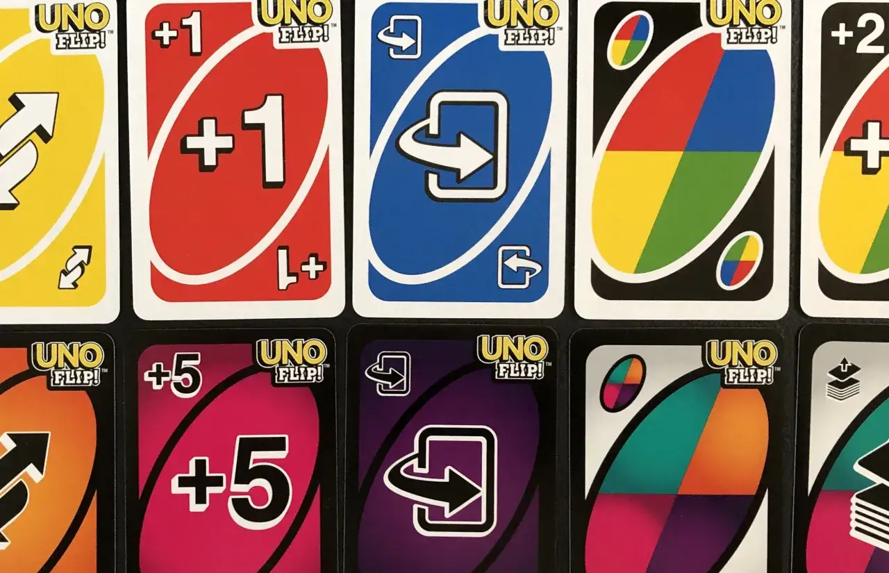 Karty UNO Flip! z symbolami: odwrócenie, +1, +5 i zmiana koloru. Gra staje się ciekawsza!