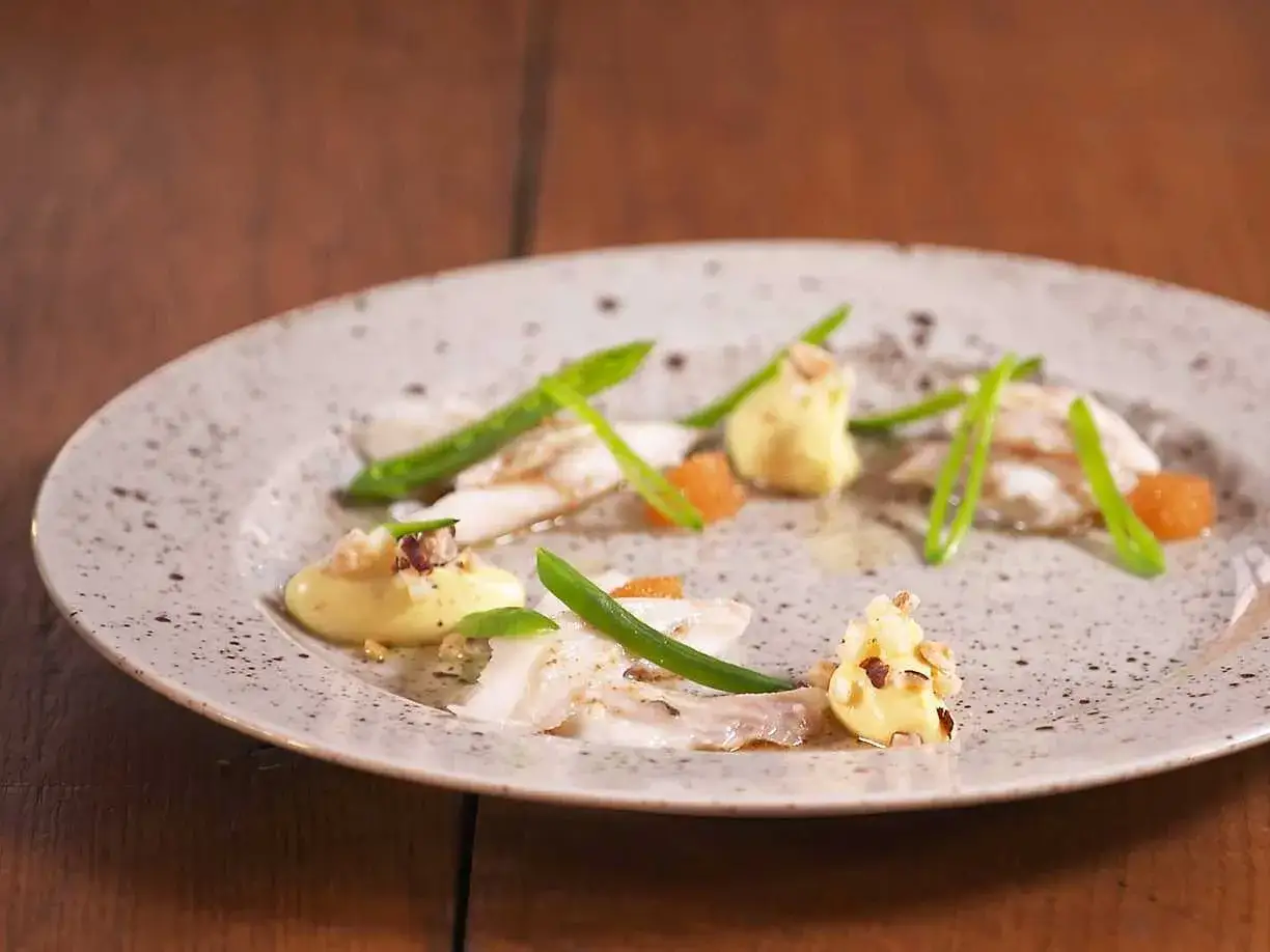 Vacker tallrik med piggvar, gröna bönor och en krämig sås. Ett elegant piggvar recept.