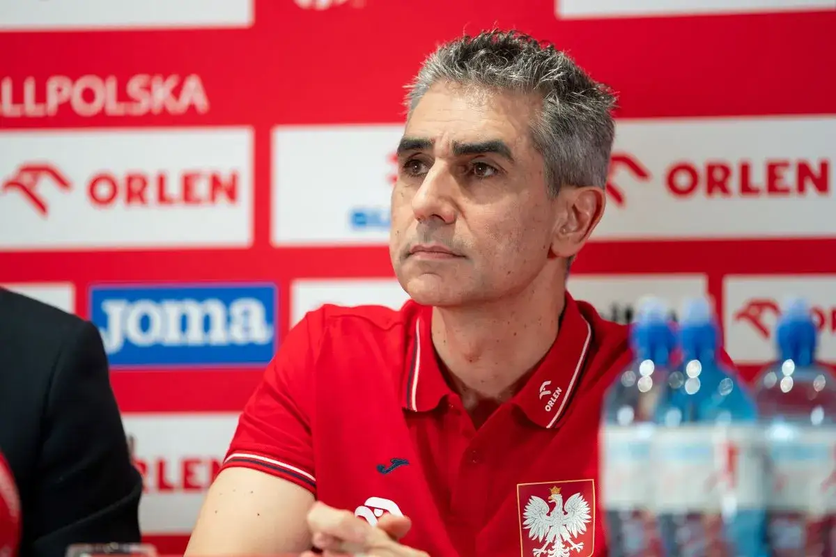 Trenerzy reprezentacji Polski w piłce ręcznej, w tym ten z orłem na piersi, podczas konferencji prasowej.