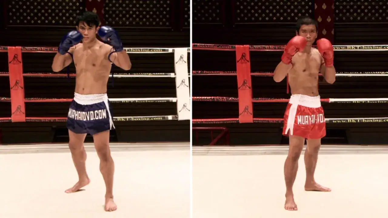 Two fighters in a boxing ring, one in blue shorts, the other in red, both in a right hand boxing stance, ready to spar.