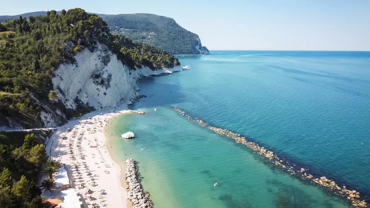 La splendida **campofilone spiaggia** con scogliere bianche, mare cristallino e ombrelloni colorati.
