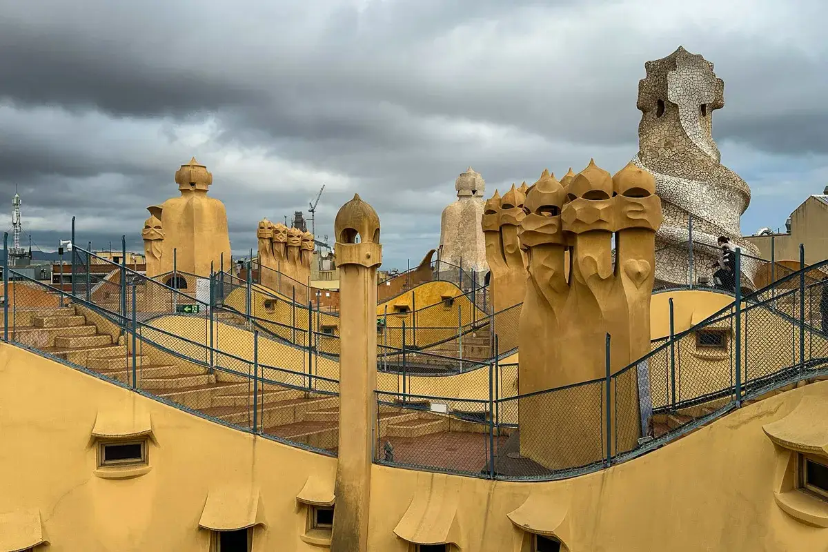 Dach Casa Mila w Barcelonie, z rzeźbiarskimi kominami przypominającymi hełmy i twarze.