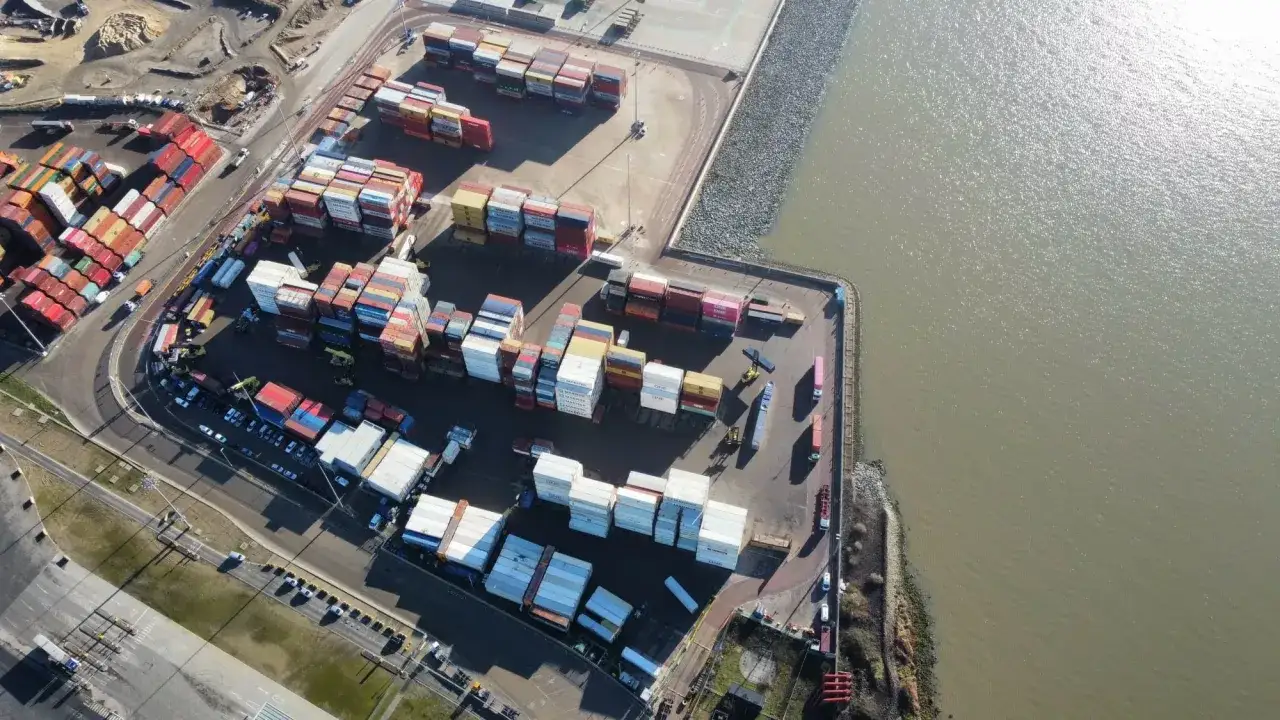 Luftaufnahme des London Gateway Ports mit vielen Containern, Kränen und Schiffen, die auf dem Wasser liegen.