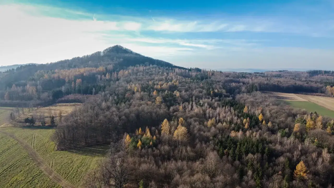 Ostrzyca Proboszczowicka w jesiennej szacie, otoczona lasami i polami.