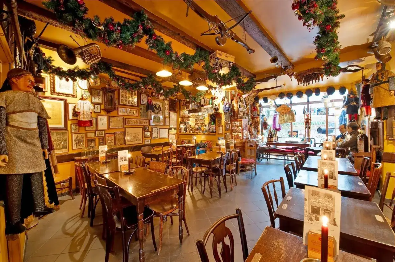 Interno di un locale a Bruxelles, con decorazioni natalizie, foto alle pareti e manichini. Un'atmosfera da vero delirium.
