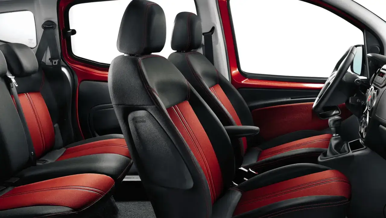 Interni del Fiat Qubo a benzina con sedili bicolore nero e rosso, cuciture a vista e finiture sportive.