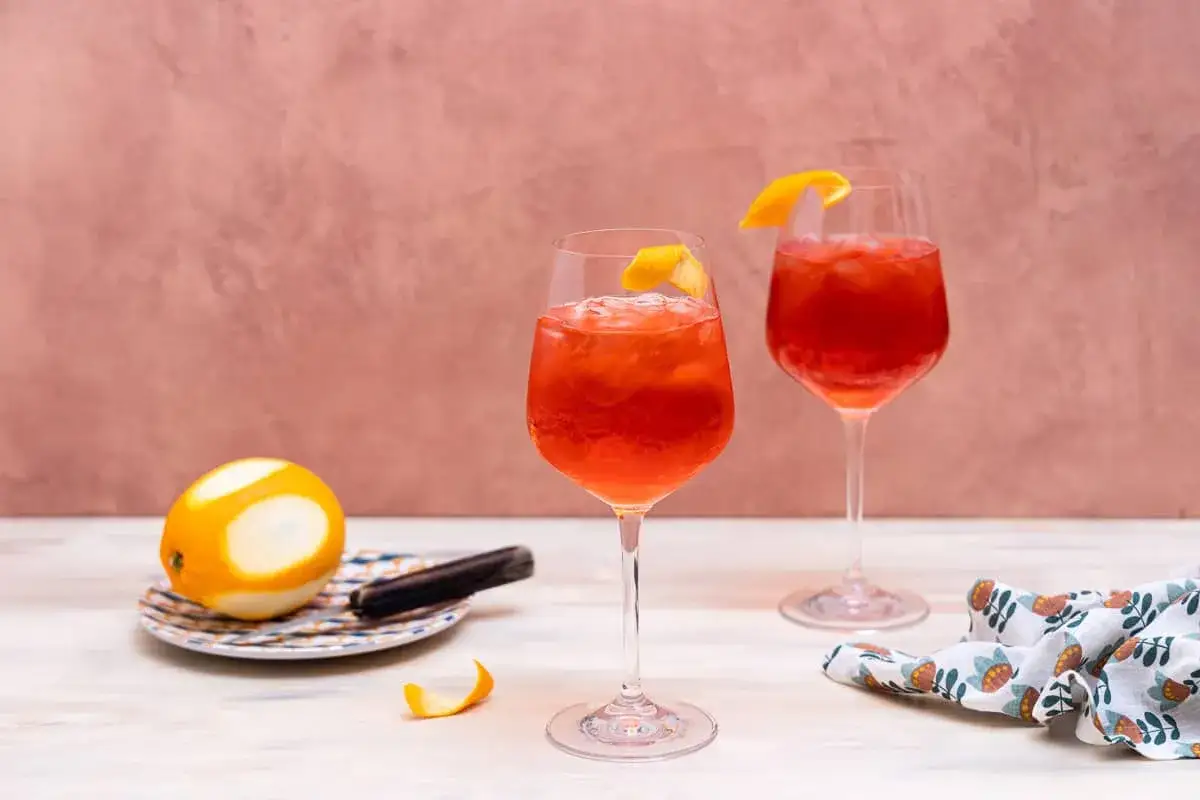 Dwa orzeźwiające Campari Spritz z pomarańczą i lodem, gotowe do degustacji.