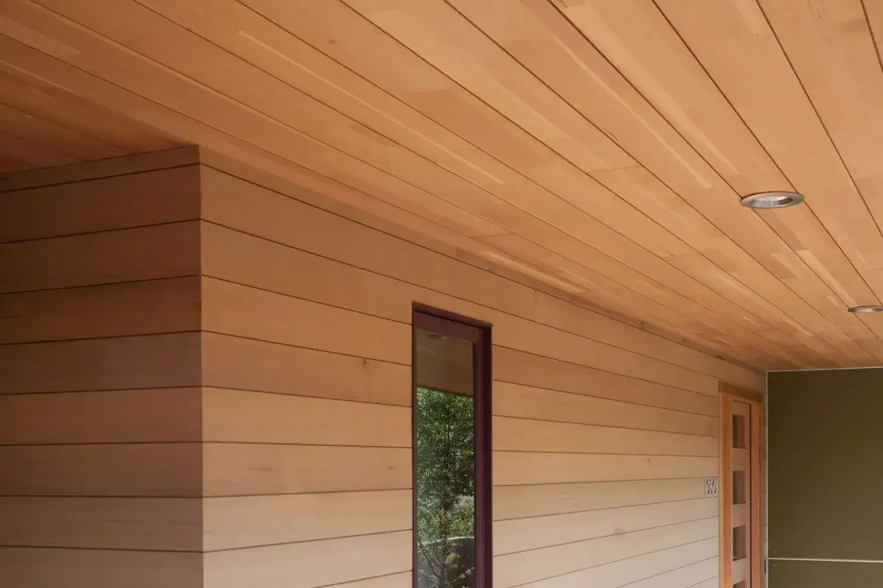 Fachada de madera con techo a juego. La madera natural resalta la pregunta: con que pintura se pinta la madera para mantener su belleza.