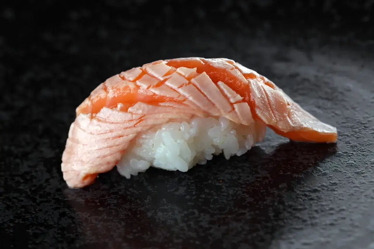 Nigiri z łososiem, klasyka japońskiej kuchni. Delikatny ryż i soczysta ryba tworzą idealne połączenie.