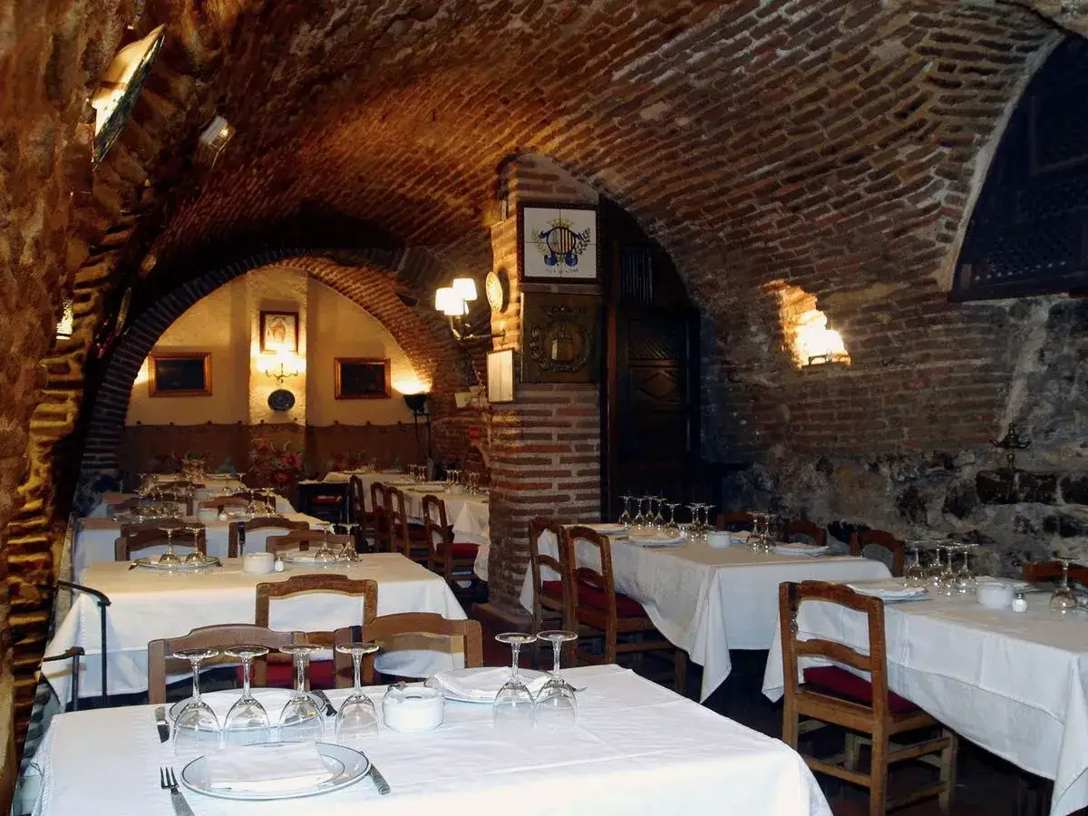 Salón abovedado de ladrillo con mesas puestas, evocando el ambiente del restaurante más antiguo de España.