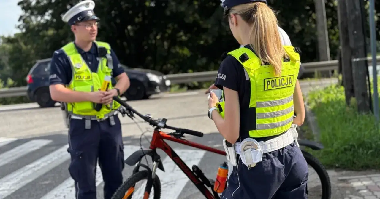 Policjanci kontrolują rowerzystę, sprawdzając, czy nie doszło do jazdy rowerem po alkoholu.