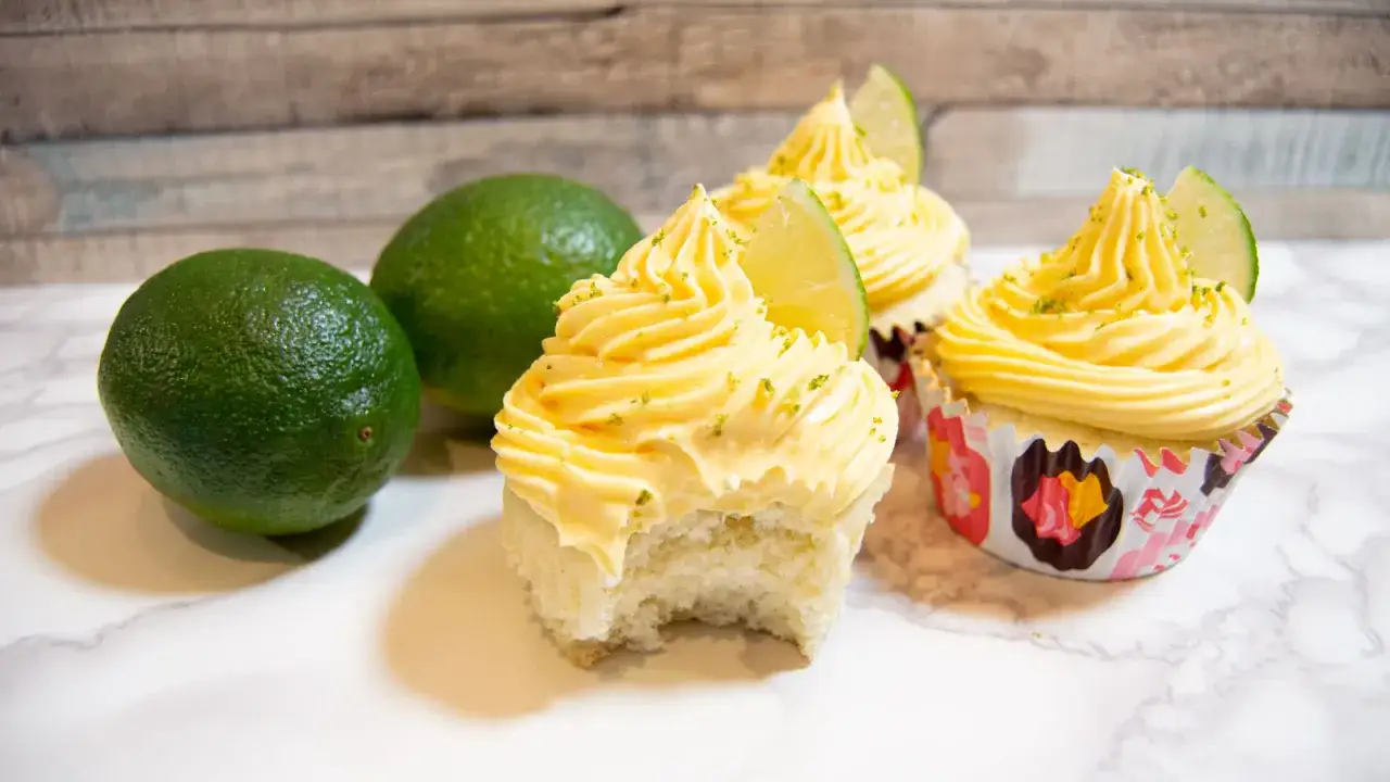 Cupcakes med limefrosting, inspirerade av c&oacute;mo hacer mangoneadas. Tv&aring; limefrukter ligger bredvid.