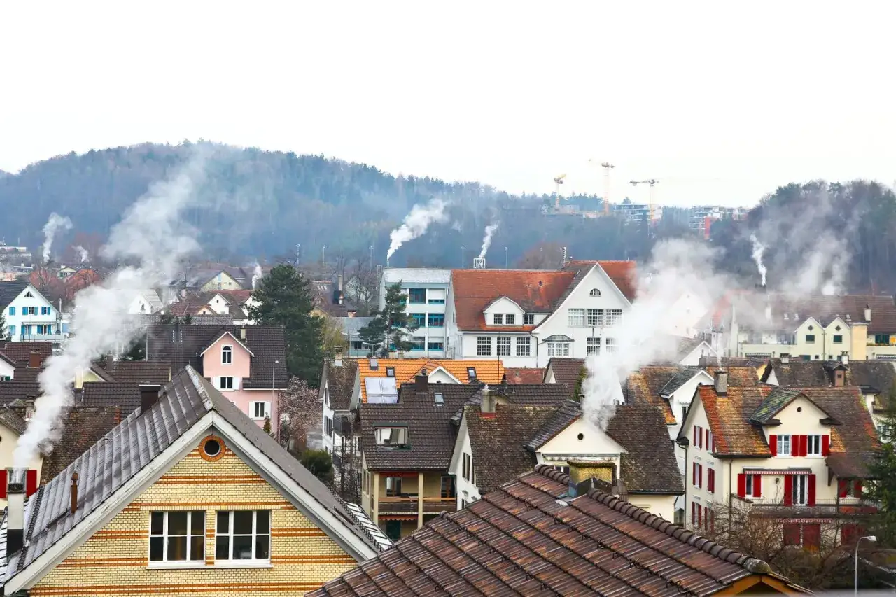 Dym z kominów nad miastem. Jak zapobiegać smogowi? Brainly podpowiada: ogrzewaj domy ekologicznie.