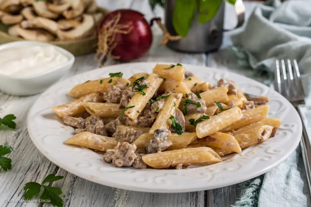 Penne cremose con salsiccia e funghi, un piatto invitante e saporito.