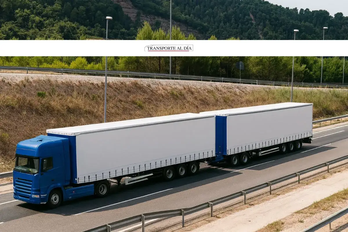 Un mega camión azul de doble remolque blanco circula por una autopista.