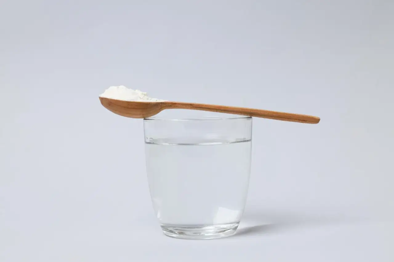 Un cucchiaio di polvere bianca, forse un farmaco per il vomito dei bambini, &egrave; pronto per essere sciolto in un bicchiere d'acqua.