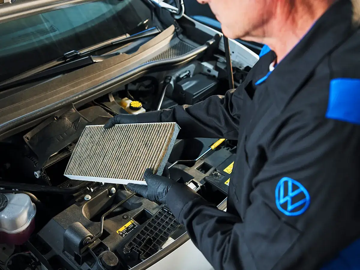 Mechanik pokazuje zapchany filtr kabinowy, jeden z objawów problemów z wentylacją w aucie.