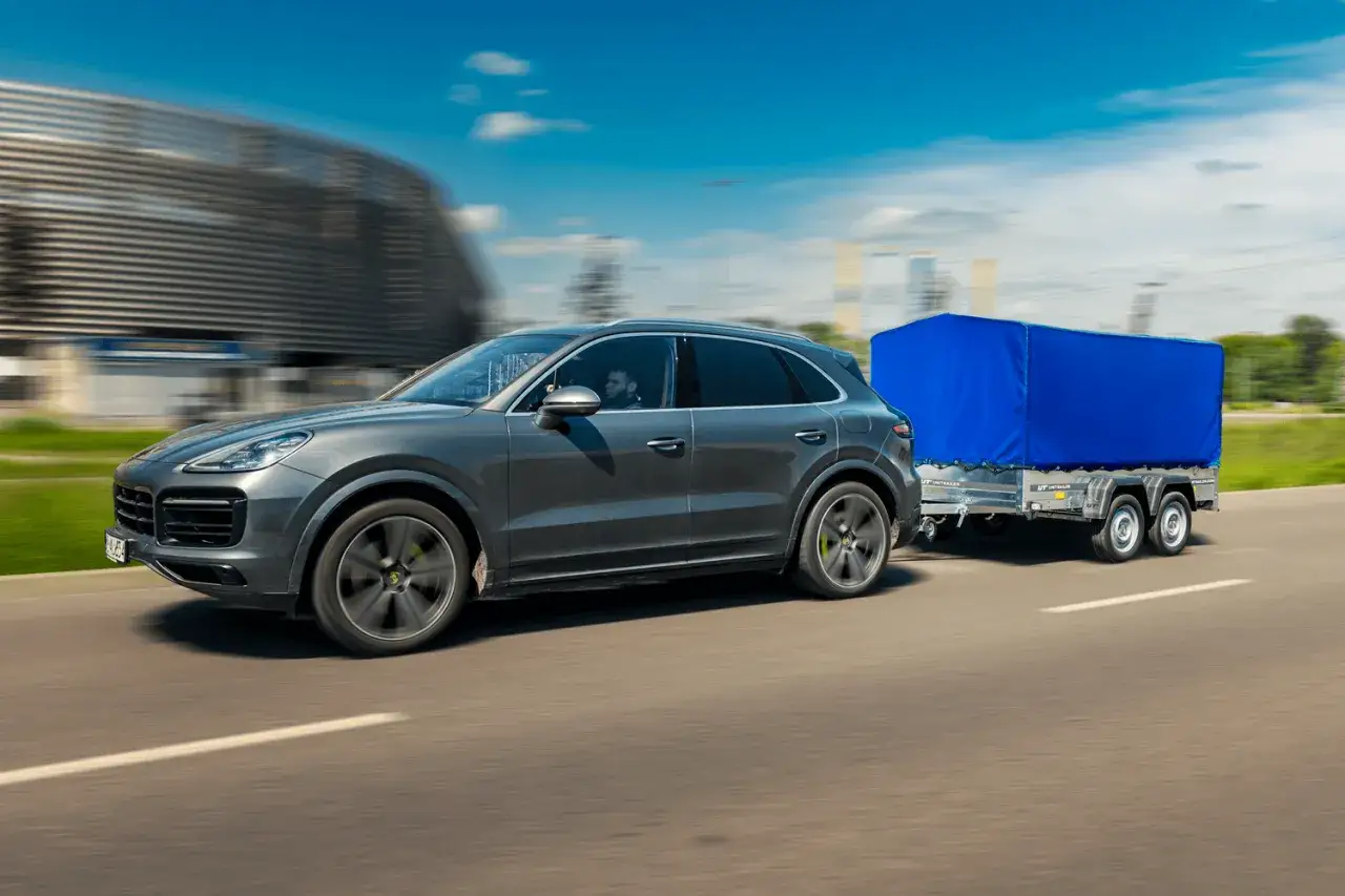 Szary SUV z przyczepą pod niebieską plandeką. Pytanie: do ilu ton można jeździć na kat B?